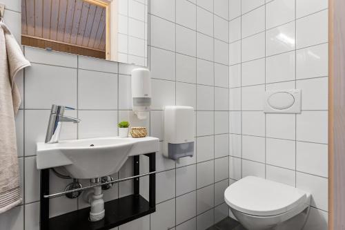 a white bathroom with a toilet and a sink at Mikkelparken Ferietun in Kinsarvik