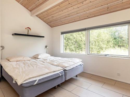 a bedroom with a bed and a large window at Four-Bedroom Holiday home in Ålbæk 4 in Ålbæk