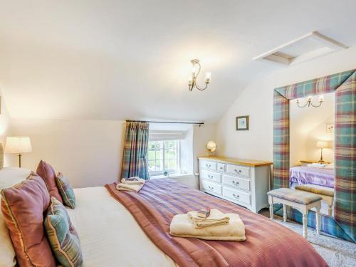 a bedroom with a large bed and a dresser at Bimble Cottage in Ingham