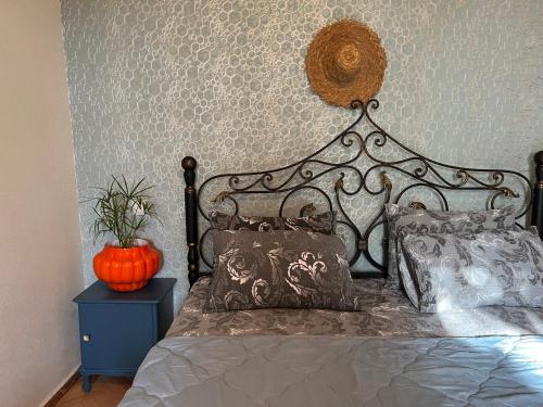 un letto con testiera decorata e cuscini in una camera da letto di Lola Apartments a Tbilisi City