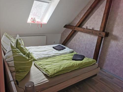 un letto con lenzuola e cuscini verdi in una stanza di Ferienwohnung Sonnenhof a Ammelsdorf