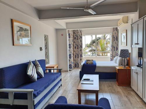 a living room with a blue couch and a bed at Gooderson Leisure Silver Sands 2 Self Catering and Timeshare Lifestyle Resort in Durban