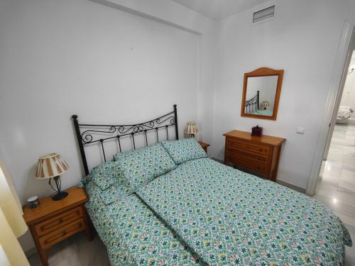 Schlafzimmer mit einem Bett, einer Kommode und einem Spiegel in der Unterkunft GRAN APARTAMENTO CERCA DE LA PLAYA CON PISCINA en EL CENTRO in Fuengirola