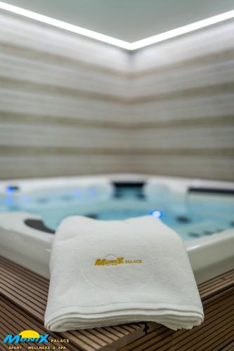 a towel sitting on a table next to a bath tub at Monix Palace Zlatibor in Zlatibor
