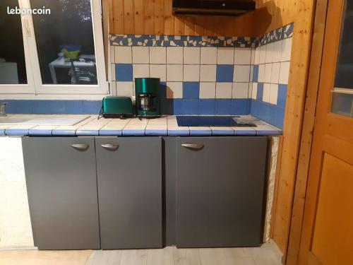 a kitchen with a counter with blue and white tiles at Gite Clé Vacances Courchaton in Courchaton