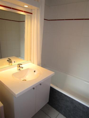 une salle de bain avec un lavabo, un miroir et une baignoire dans l'établissement T2 Idéal Ski, rando et cures, à Cauterets
