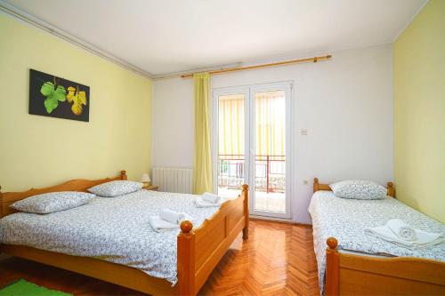 1 dormitorio con 2 camas y ventana en Apartment Bojic, en Vodice