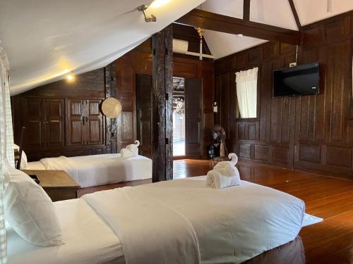 a bedroom with two beds and a flat screen tv at DONPIN8-Timeless House Chiang Mai in Chiang Mai