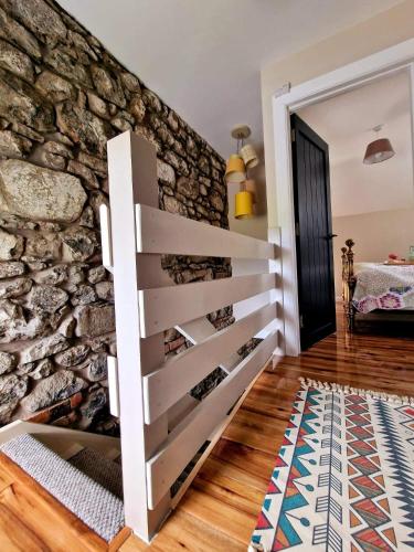 a room with a stone wall and a stair case at Beech Tree Cottage in glenwherry