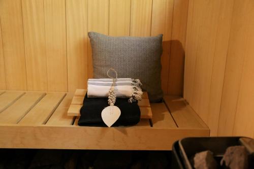 a wooden bench with a pillow and a key on it at AuxiliumWellness Get Back to Serenity in Grobbendonk