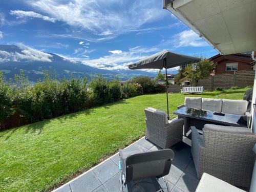 une terrasse avec une table, des chaises et un parasol dans l'établissement Apartment „AlpView“,Tirol mit Sauna und Pool, à Vomp
