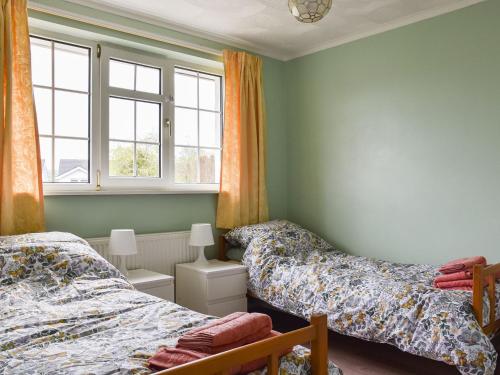 a bedroom with two beds and a window at Brookside in Coychurch