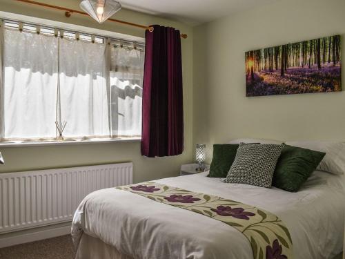 een slaapkamer met een bed en een schilderij aan de muur bij Farriers in Bransgore