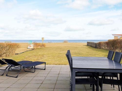 um pátio com uma mesa e cadeiras e o oceano em 5 person holiday home in Frederikshavn em Frederikshavn