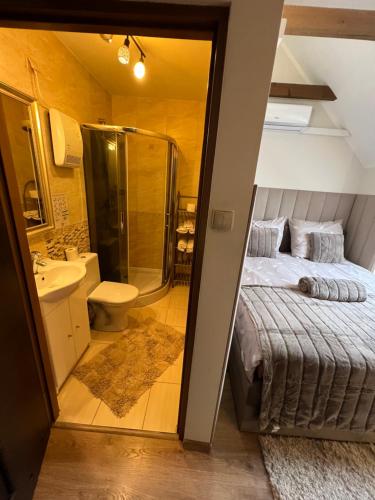 a bathroom with a bed and a shower and a sink at Comfort Zone Ostróda Apartment 1 in Grabinek
