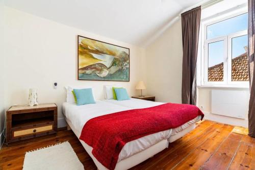 una camera da letto con un grande letto con una coperta rossa di Large family flat in Campo de Ourique a Lisbona