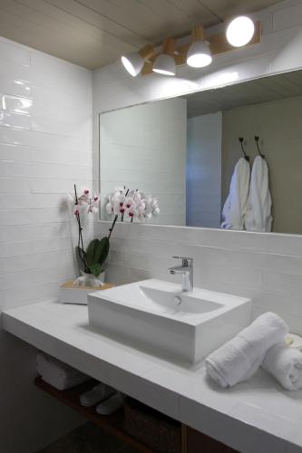 a white bathroom with a sink and a mirror at La Bastide du Beausset-Vieux in Le Beausset