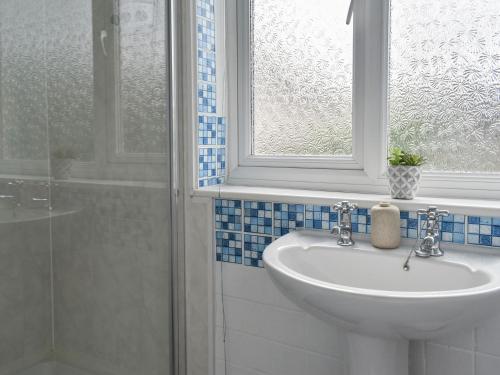 a bathroom with a sink and a window and a shower at The Glen in Par