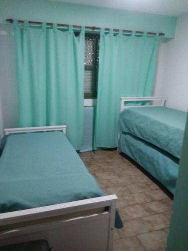 um quarto com 2 camas e cortinas azuis em Departamento Nueva Córdoba em Córdova