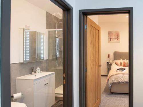 a bathroom with a sink and a bedroom with a bed at Bryn Eglwys in Llanegryn