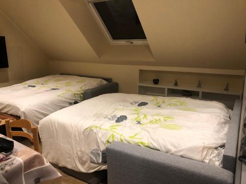two beds in a room with a tv on the ceiling at Logement @ 10 personnes avec piscine intérieure 31 degrés zoo de la FLECHE 24 h du Mans in La Flèche