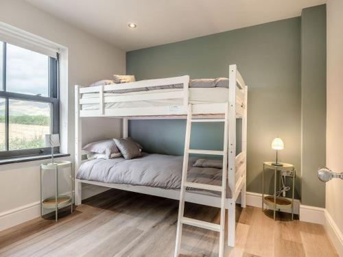 a bedroom with two bunk beds in a room at Gwrlodde in Talgarth
