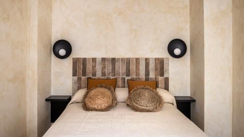 um quarto com uma cama com almofadas em Edificio Lola 3 em Lucena
