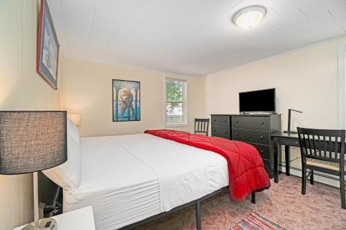 una camera da letto con un letto con una coperta rossa sopra di Carol's Cottage a Empire