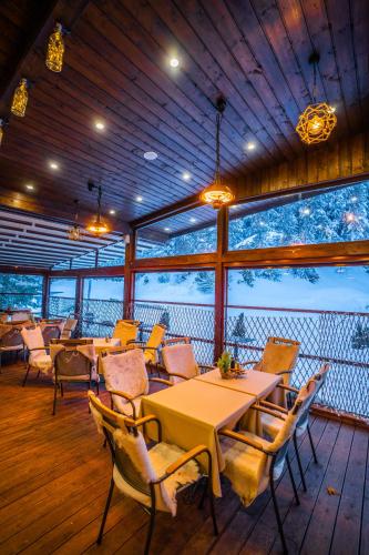 a dining room with tables and chairs and windows at Hotel and SPA Moreni in Sofia
