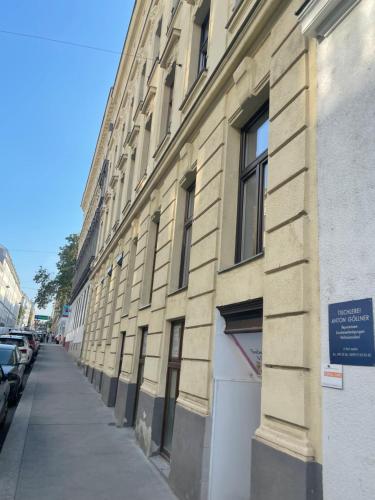 ein Gebäude auf einer Straße, an der Autos geparkt sind in der Unterkunft Your home in Vienna Self Check In in Wien