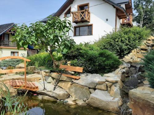 a garden with a pond and a house at Apartament Huba in Huba