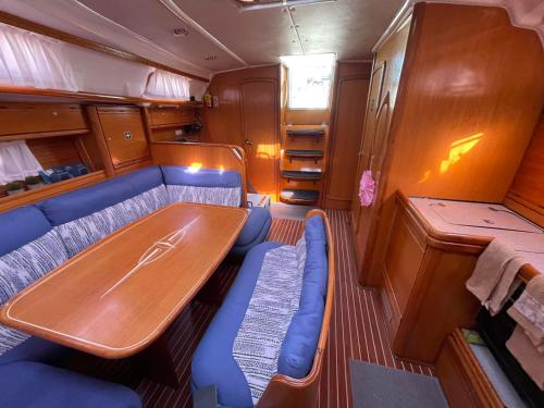 塞薩羅尼基的住宿－AIDA Sailing Boat，一间带木桌和蓝色座椅的用餐室