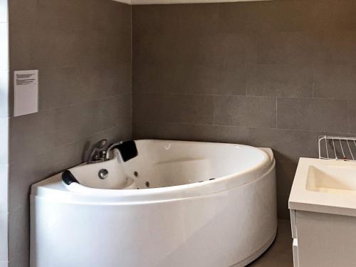 a white bath tub in a bathroom with a sink at 12 person holiday home in R m in Rømø Kirkeby