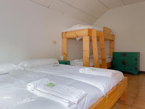a bedroom with two bunk beds and a ladder at Arena Surf Hotel in Somo