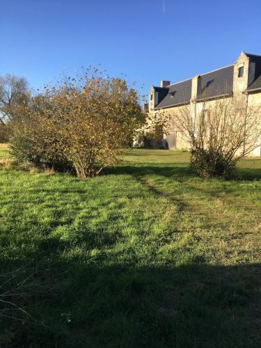 un campo de hierba con un edificio en el fondo en Manoir de Valette 