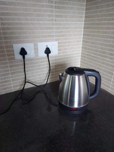 a tea kettle sitting on a counter in a room at Lovely 1bedroom compact condo at 9th floor in Kelambākkam