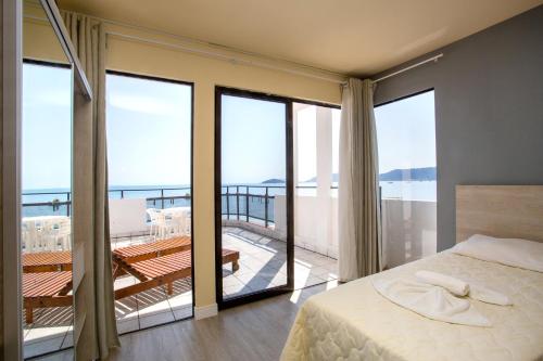 a bedroom with a bed and views of the ocean at Hotel Vila Mar in Florianópolis