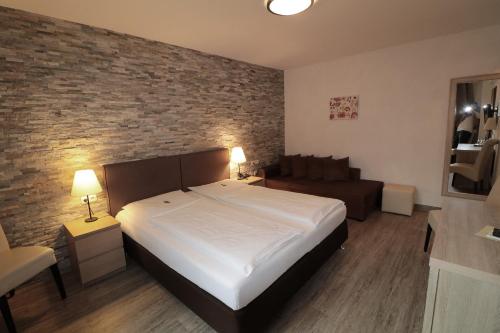 a bedroom with a large bed and a brick wall at Hotel Central in Zeven