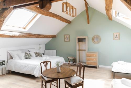 a bedroom with a bed and a table and chairs at Domaine de Jouarre in Jouarre