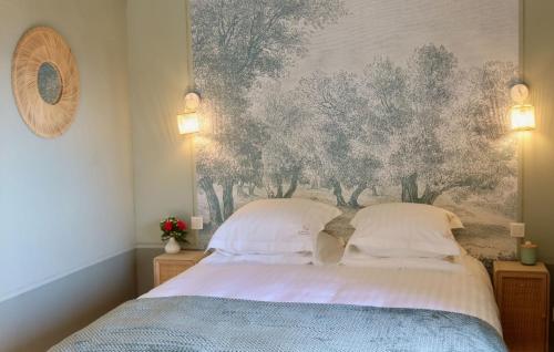 a bedroom with a bed with a painting on the wall at La Bastide du Beausset-Vieux in Le Beausset