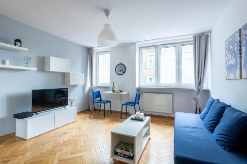 ein Wohnzimmer mit einem blauen Sofa und einem Tisch in der Unterkunft Śliska 10 Prywatne mieszkanie 300m od Dworca Centralnego oraz metra ONZ in Warschau