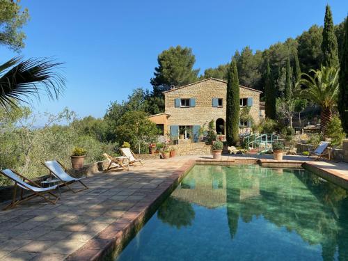 una villa con piscina di fronte a una casa di La Bastide du Beausset-Vieux a Le Beausset