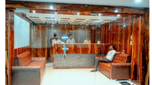 a man sitting on a couch in a waiting room at Hotel DC Star in Tarapith