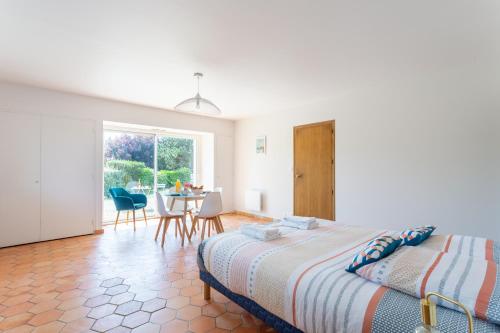 Un dormitorio con una cama y una mesa y sillas. en Le Jardin des Dunes, en Saint-Cast-le-Guildo