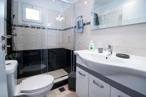 a bathroom with a toilet and a sink and a shower at Sunset Apartments Free shuttle from Athen's Airport in Spáta