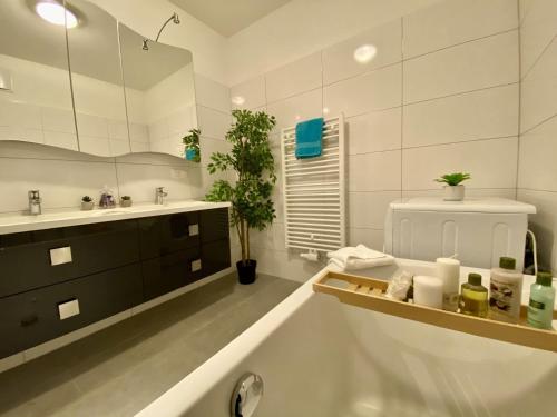 a bathroom with a tub and a sink and a mirror at Apartment Seenah Zentral in Pörtschach am Wörthersee