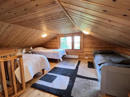a room with two beds in a log cabin at Kotamäki B in Syöte