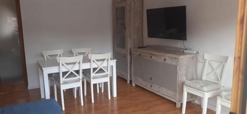 a dining room with a table and chairs and a television at Pis Acollidor amb LLar de Foc, al Centre Camprodon in Camprodon