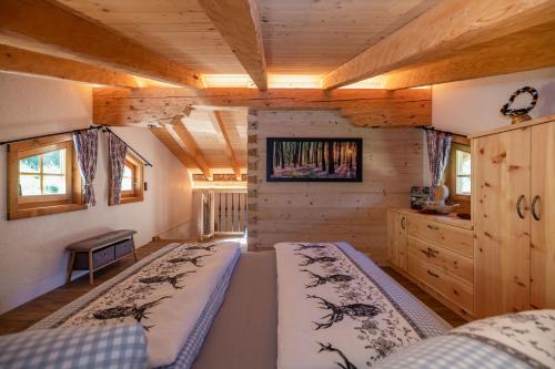 um quarto com 2 camas num chalé de madeira em Ferienhütte Sternenblick em Grosskirchheim