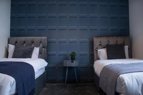 吉林漢姆的住宿－The Countryman Den - 65 Inch TV - Super Wifi，蓝色墙壁客房的两张床